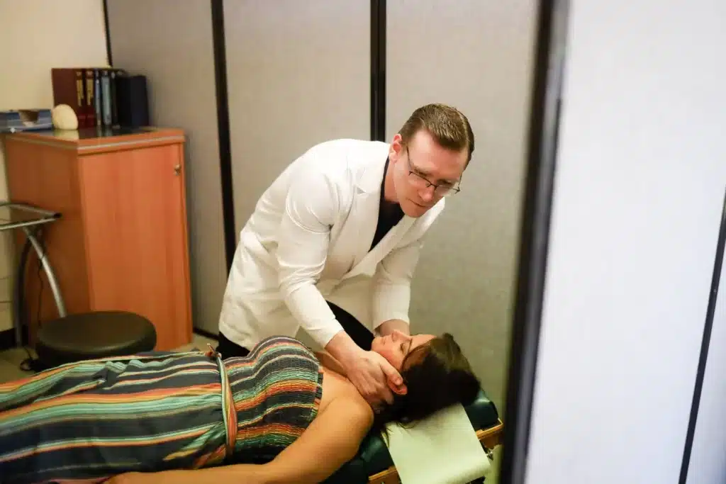 Dr. Michael Brandon, D.C., treating a patient's neck in the Colts Neck treatment room