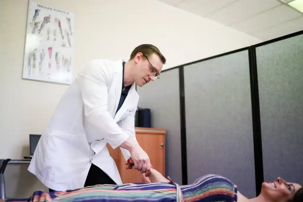 Dr. Michael Brandon, D.C., examining a patient's wrist