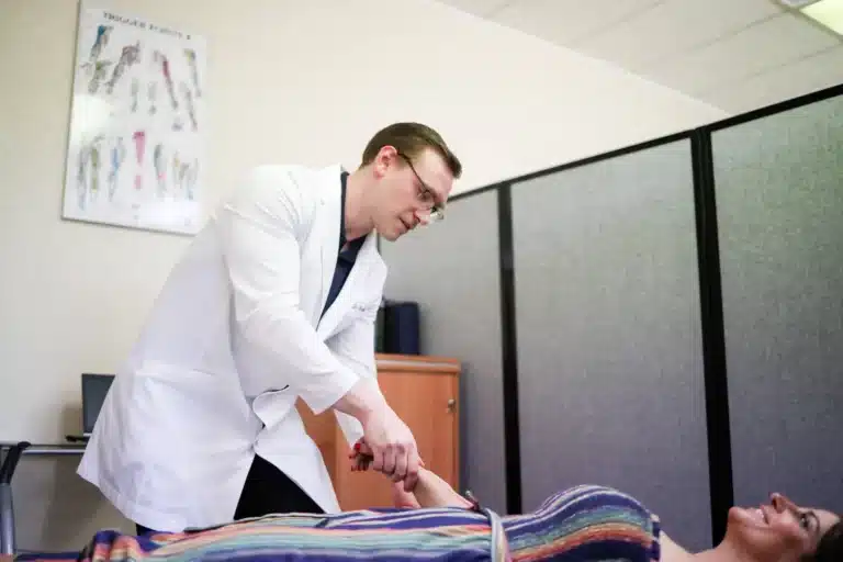Dr. Michael Brandon, D.C., examining a patient's wrist