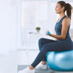 attractive-hispanic-lady-with-dumbbells-sitting-on-GEBTG2G.jpg