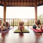 three-women-practicing-paschimottanasana-pose-at-y-P7F46KA.jpg